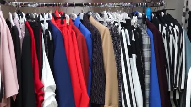 Különböző női ruhák egy vállfán a boltban. - Felvétel, videó