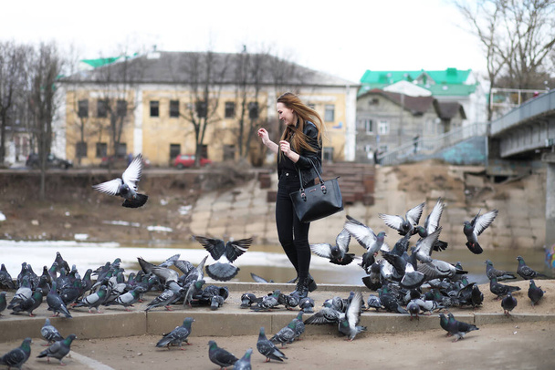 Dziewczyna na spacerze po parku i stado gołębi - Zdjęcie, obraz