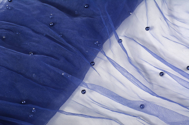 Tissu tulle festif en dentelle froissée bleu clair magnifiquement drapée avec des étincelles. texture des vêtements de mariage, voile, robe, jupe. Utilisez pour coudre l'industrie de la mode avec de l'espace de copie. Gros plan mise au point douce - Photo, image
