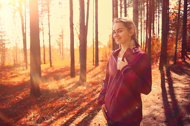 female sports style autumn forest, fitness tourism in a yellow park leaf fall sun - 写真・画像