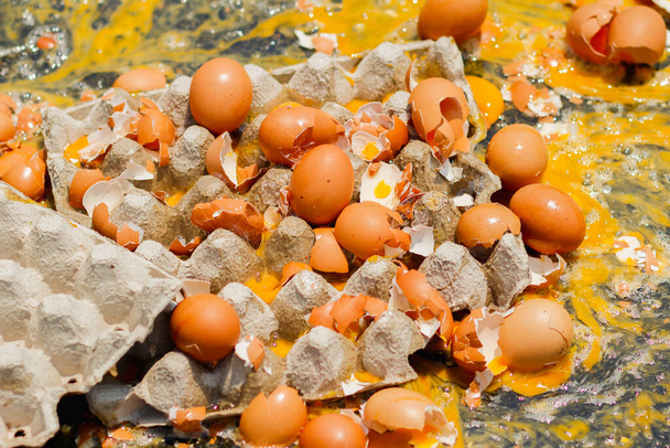 Meerdere eieren crashte op de weg als gevolg van een ongeval in een ei levering vrachtwagen die op het punt stond om eieren te leveren aan restaurants in de ochtend. Concept van onopzettelijk verlies en vertraging - Foto, afbeelding