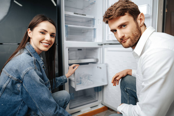 Young couple selecting new refrigerator in household appliance store - Fotografie, Obrázek