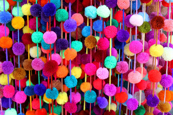 Colorful strands of pom-poms hang at a market in Chiapas, Mexico. - Photo, Image