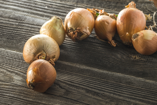 lots of onions on a table made of wood - Fotoğraf, Görsel