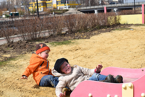 Children on the slide at the playground. The fall. - Photo, Image