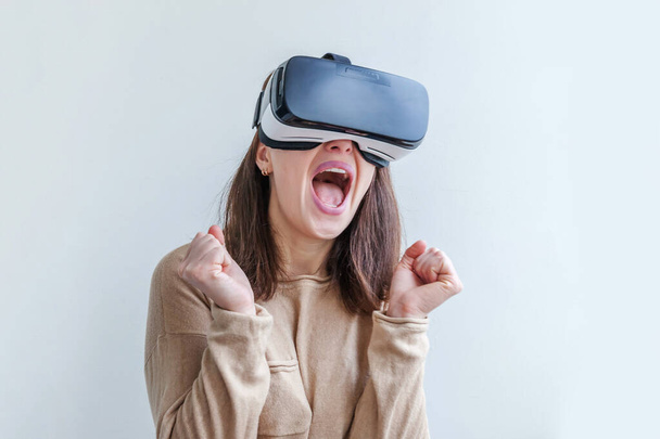 Smile young woman wearing using virtual reality VR glasses helmet headset on white background. Smartphone using with virtual reality goggles. Technology, simulation, hi-tech, videogame concept - Fotoğraf, Görsel