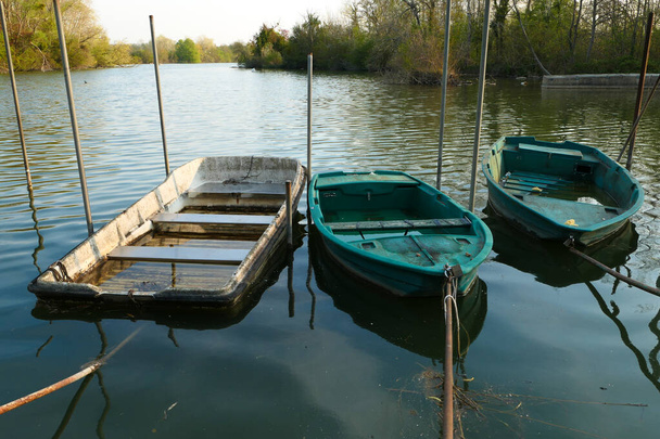 Opuštěný člun, izolovaný na jezeře. Tři veslice na vodě. - Fotografie, Obrázek