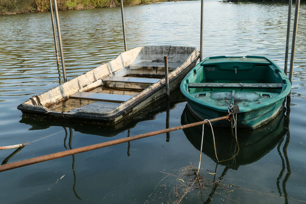 Bateau à rames abandonné, isolé sur un lac. Deux chaloupes sur l'eau. - Photo, image