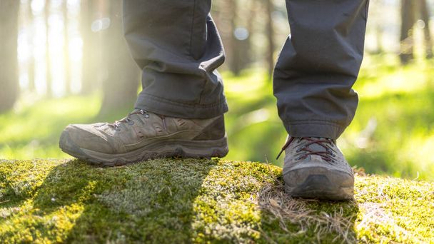 person walking through the forest in nature. Healthy life style. Boots in the foreground - Foto, imagen