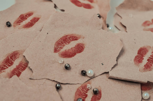 imprint of womans lips in red lipstick with inscription love you on wrapped paper, many kisses - Photo, image