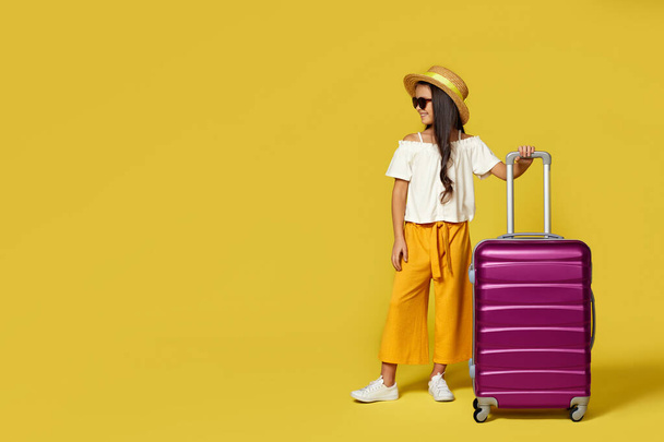 Щаслива маленька дівчинка в капелюсі з рожевою валіза
 - Фото, зображення