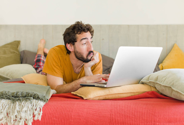 young bearded man on a bed with a laptop - Foto, immagini