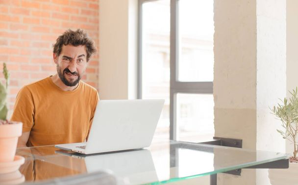 young bearded man working at home with a laptop - Foto, imagen