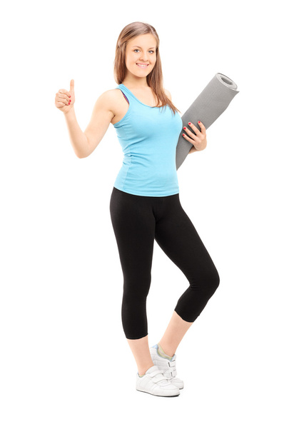 Woman holding exercise mat - 写真・画像