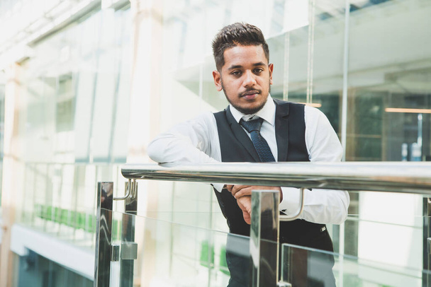 Portrait of a businessman in suit are standing on the background of glass offices. - Photo, image