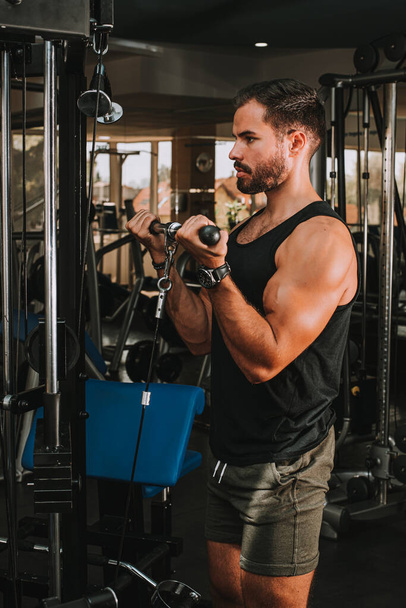 handsome muscular man exercising in gym - Zdjęcie, obraz