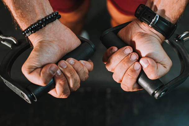 close-up of hands of muscular man exercising in gym - Foto, imagen