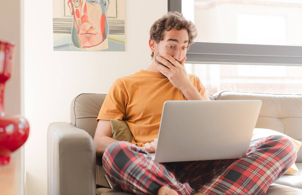 young bearded man on a couch with a laptop - Foto, imagen