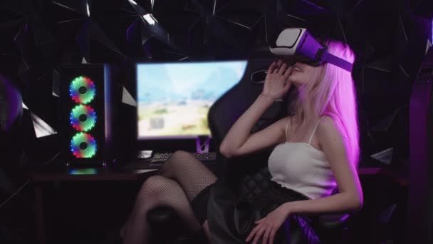 Mladý blondýnka hráč dívka sedí v křesle nosí VR brýle - Záběry, video
