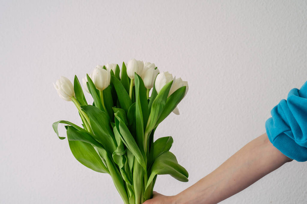 chica con manicura roja sostiene tulipanes blancos - Foto, imagen