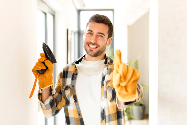 handyman smiling proudly and confidently making number one pose triumphantly, feeling like a leader - 写真・画像