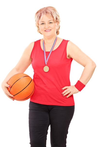 Woman with medal holding basketball - Foto, afbeelding