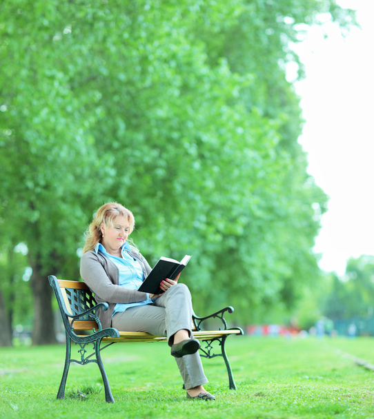 Woman reading book in park - Zdjęcie, obraz