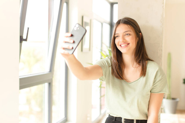 young pretty girl with a smartphone  at home - Foto, Imagem