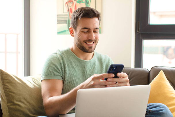 young handsome man using his smartphone at home - Foto, Imagem