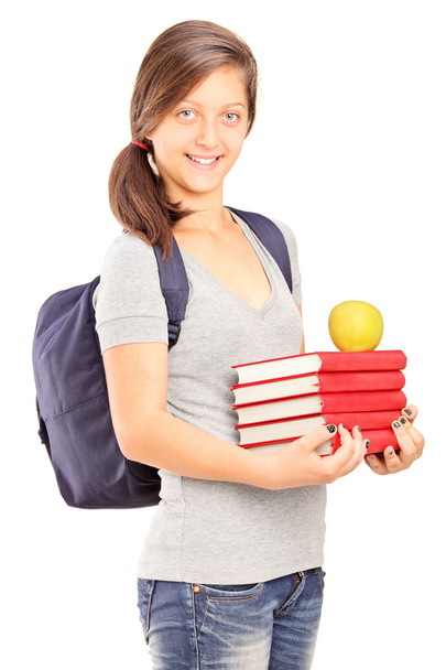 Schoolgirl holding pile of books - Фото, зображення