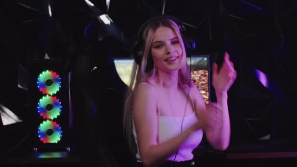 Młoda blondynka uśmiechnięta gracz dziewczyna odwraca się od monitora PC i pokazuje rozchmurz się gest - Materiał filmowy, wideo
