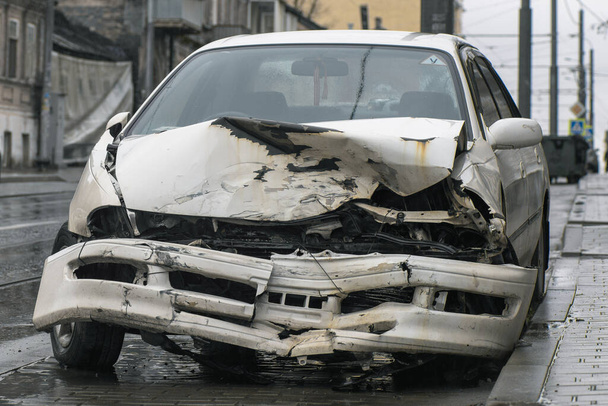 Sokakta araba kazası. Şiddetli bir kazadan sonra hasar gören bir araba şehir caddesinde duruyor. Kaza sigortası kavramı. - Fotoğraf, Görsel