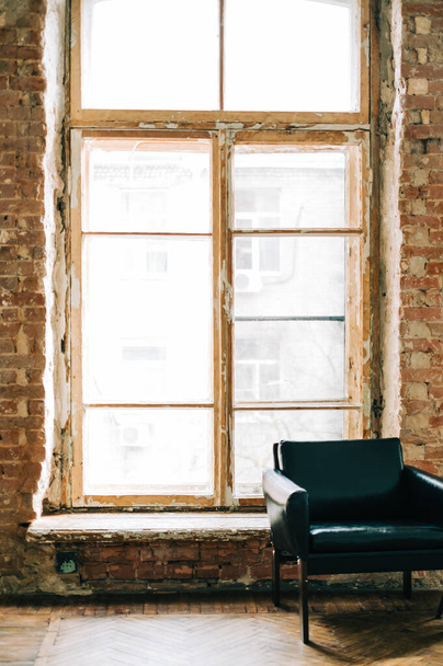 Big wooden window with white sofa in old vintage living room with brick walls. - Valokuva, kuva