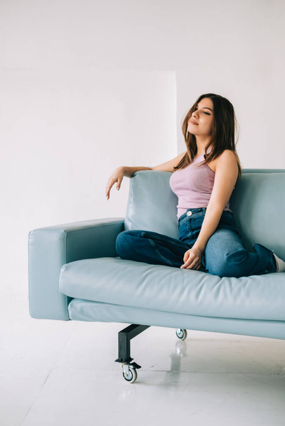 Young calm caucasian woman relaxing, sitting on sofa in modern living room, lazy happy woman resting at home. - Foto, immagini