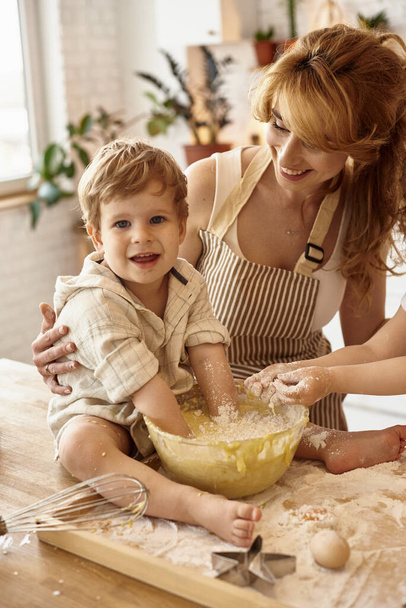 son helps mom in the kitchen - Foto, imagen