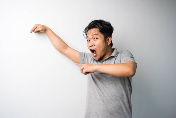 Portrait of Young Asian man, pointing with exciting, happy face expression, new fresh idea for advertisement. isolated selective focus. - 写真・画像
