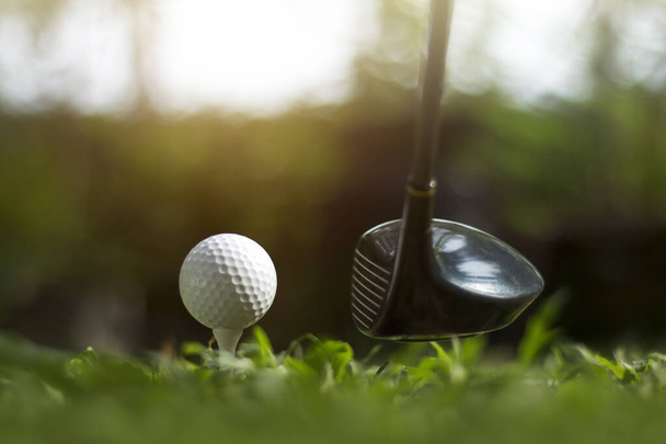 Golfclubs en golfballen op een groen gazon in een prachtige golfbaan met ochtendzon.Klaar voor golf in de eerste short.Sport die mensen over de hele wereld spelen tijdens de vakantie voor gezondheid. - Foto, afbeelding