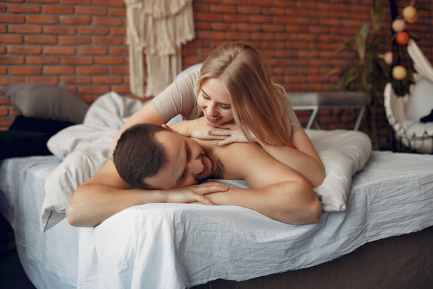 Couple sitting on a bed in a room - Foto, Imagem