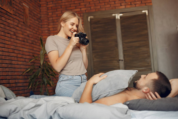 Couple sitting on a bed in a room - Foto, Imagem