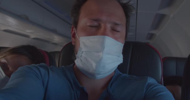 L'uomo addormentato in maschera si sveglia e guarda fuori dalla finestra dell'aereo - Filmati, video