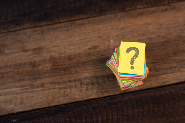 multicolored paper with QUESTION MARK on a wooden table background. questions,mystery and diversity concept. FAQ and Q&A background concept - Zdjęcie, obraz