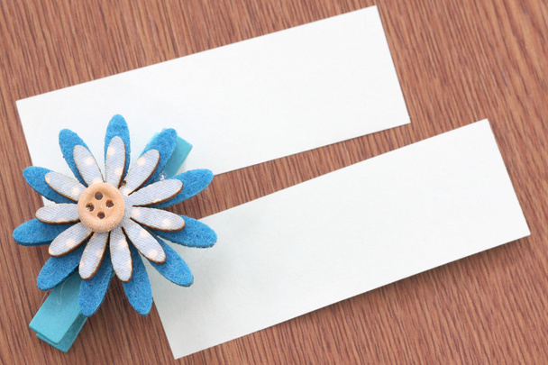 Flores artificiales azules y papel de nota pegados en madera oscura
. - Foto, Imagen