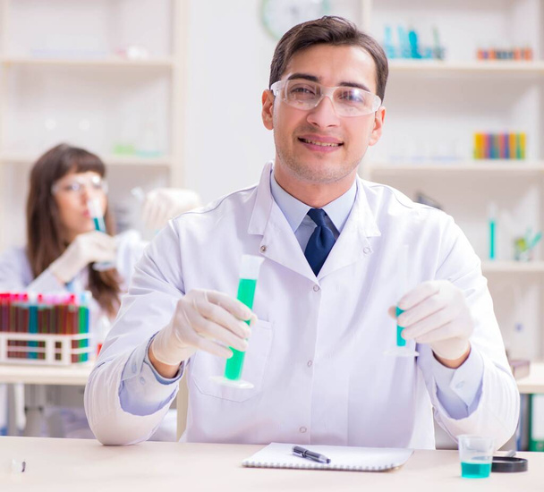 Two chemists working in lab experimenting - Foto, afbeelding