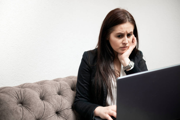 Angst gestresste blanke jonge vrouw tijdens het lezen van het computerscherm op het kantoor.Zakenvrouw met tand pijn werken in het kantoor - Foto, afbeelding