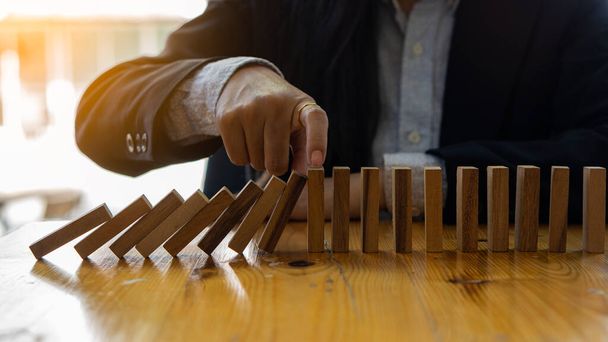 Рука бізнесмена тягне або кладе дерев'яні блоки на стіл в сучасні ідеї офісного будівництва
. - Фото, зображення