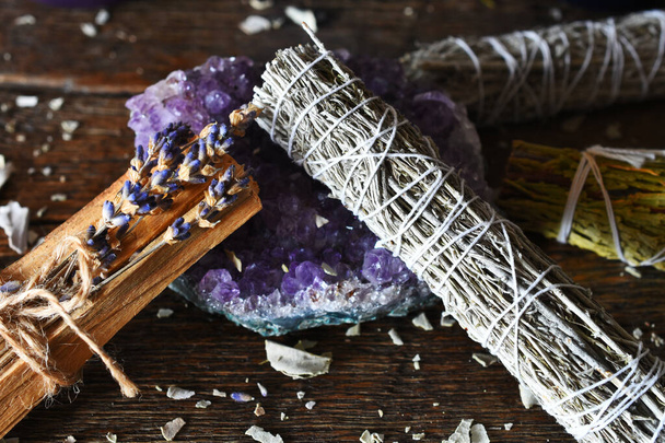 A close up image of white sage smudge bundle and amethyst crystal. - Photo, Image