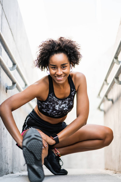 Afro athlete woman stretching legs before exercise. - Zdjęcie, obraz