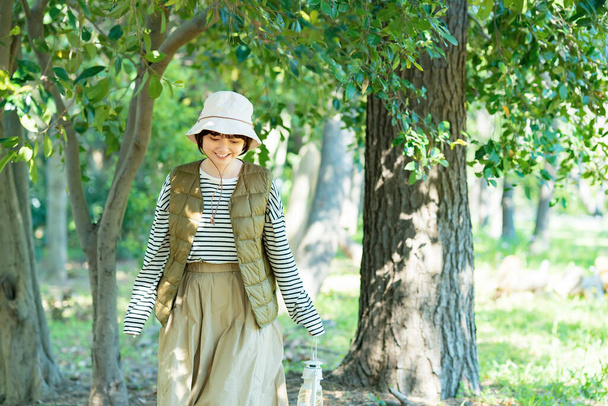 Mladá žena procházející se světlým lesem za krásného dne - Fotografie, Obrázek