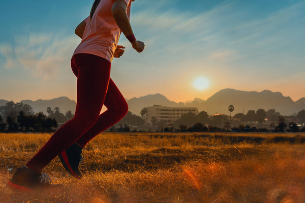 Asian woman enjoys running outside with beautiful summer evening in the countryside. - Photo, Image