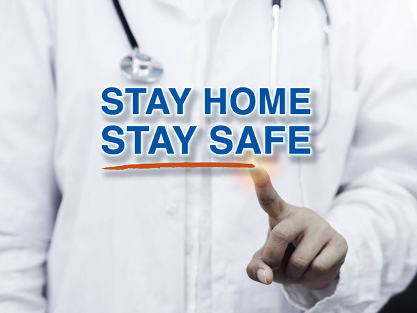 Message STAY HOME STAY SAFE and red underline stroke writing by doctor's finger in a white coat and medical stethoscope. Stay safe, self-protection, self quarantine and social disdancing concept. - Photo, Image